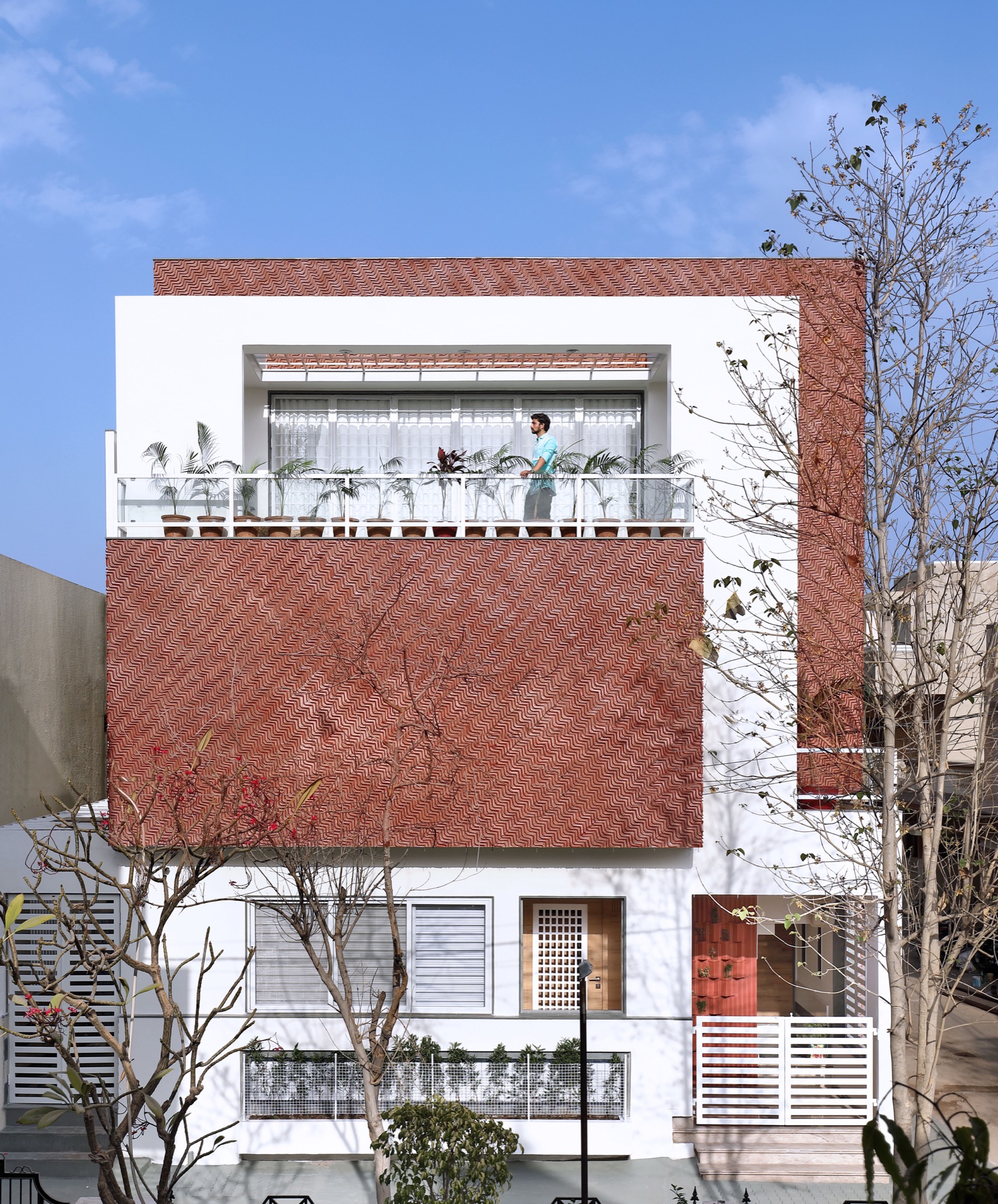Manoj Patel Design Studio creates an innovative earthy red colored clay tile cladding facade for a refurbished residence in Vadodara 1