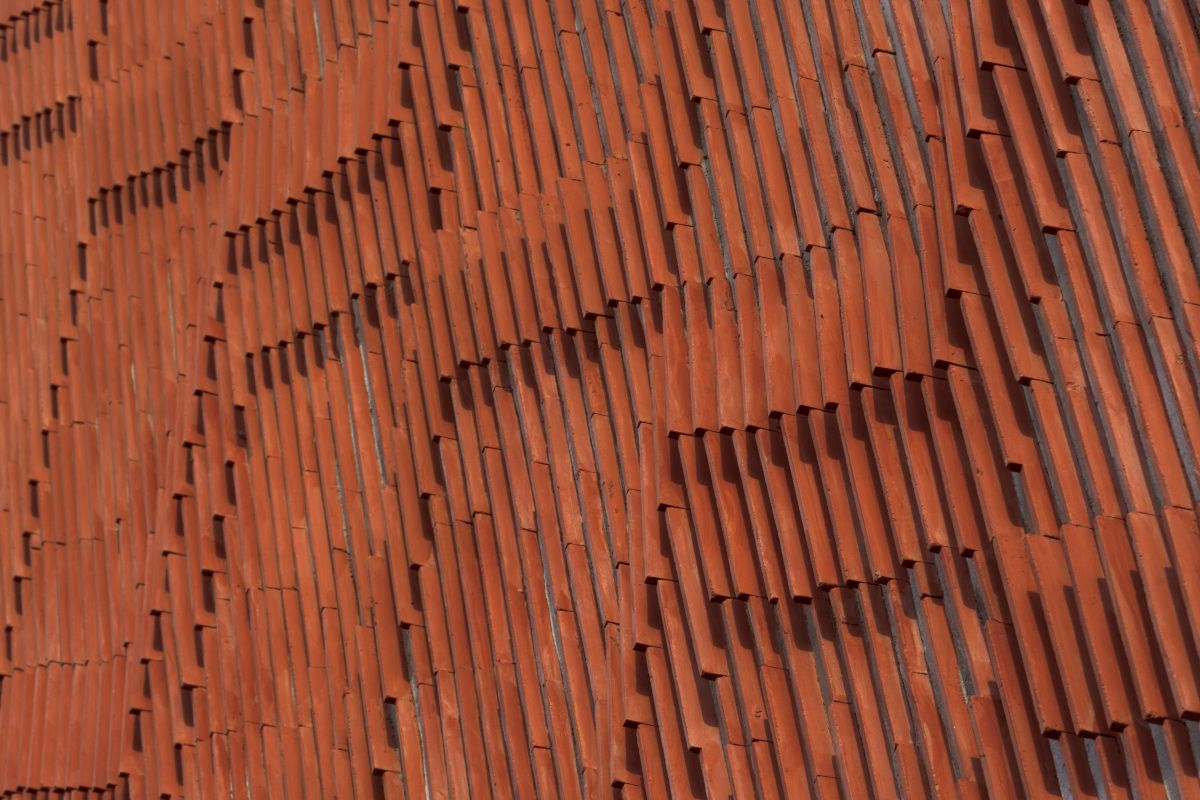 Clay roof tiles façade to minimize heat gain and has decorative function, at Vadodara, by Manoj Patel Design Studio 89