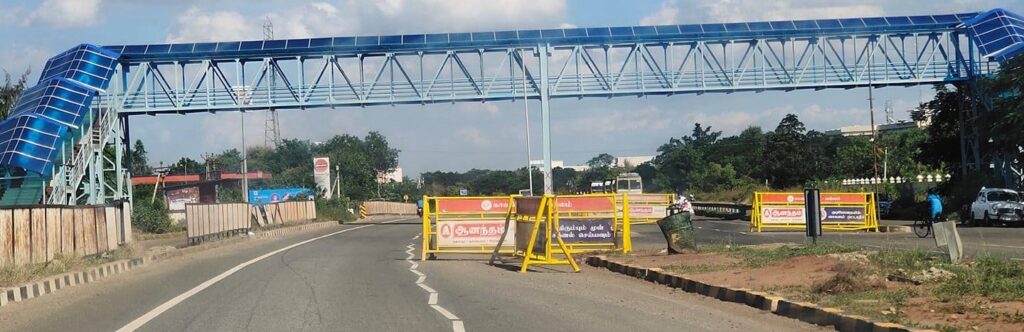 An empty two-way street with an overhead bridge, with police barricades on the street. Source: Facebook, Thanjavur photos