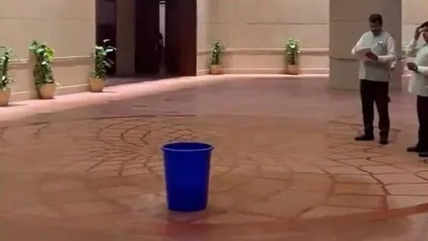 Photograph of the leaking new parliament building with bucket