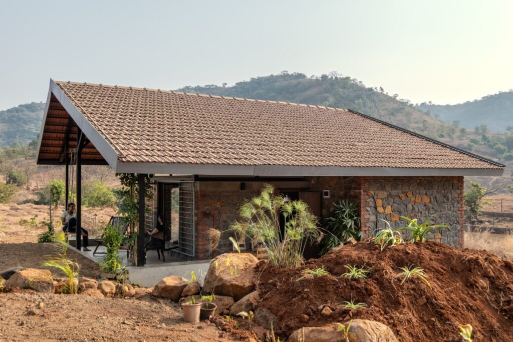 Writer's Cottage, Velhe, Maharashtra, by Fractal Chaos 30 a building with a roof and a person sitting on a porch